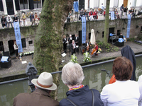 905686 Afbeelding van een optreden van dichter-schrijver Gerrit Komrij en een klein muziekgezelschap op de werf langs ...